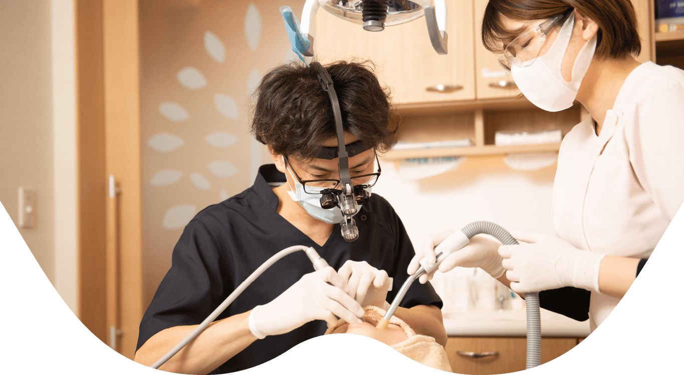 院長の齋藤彰が患者様の歯を検査をしている写真